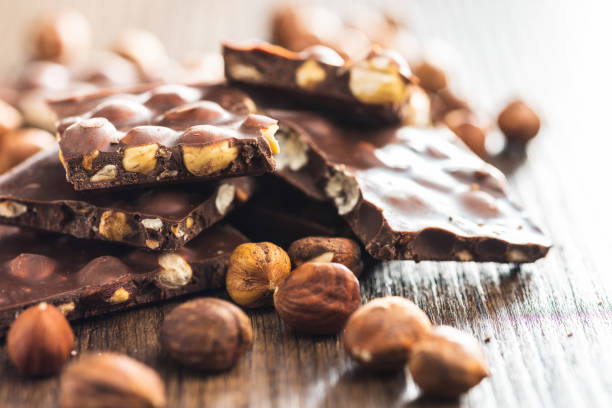 istock Broken chocolate bars with  nuts on wooden table. 1493152375