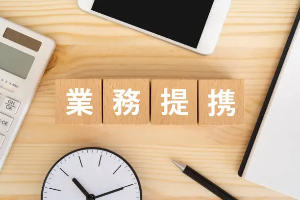 Wooden blocks with "gyomuteikei" text of concept on the table.