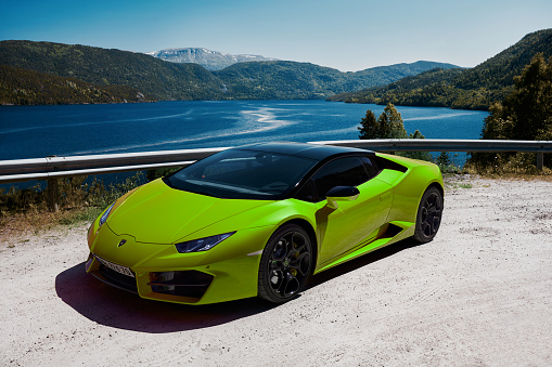 Road trip in a green Lamborghini Huracan, engine V10, 580 HP. The car parked by a lake in the mountains. Gransherad, Norway. 04.06.2016