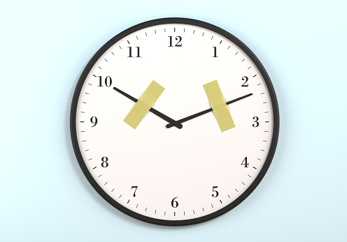 The hour and minute hands on the wall clock are stopped with tape. Stop the time concept.