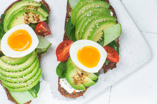 istock Sandwich with cream cheese, avocado and boiled egg on a white background 1493159743