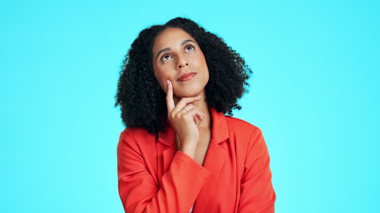 Thinking, looking up and woman in studio for ideas, mindset and planning to remember questions on blue background. Female model, decision and wondering of daydream, solution and brainstorming choice