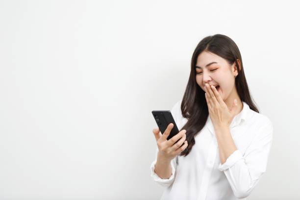 Model asian woman emotion happy and excited to win prizes with online lottery tickets on their mobile phones. stock photo