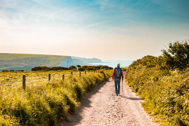 istock Senior man hiking on country path leading to Seven Sisters cliffs 1493168725