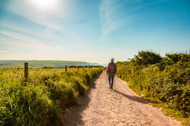istock Senior man hiking on country path leading to Seven Sisters cliffs 1493168733