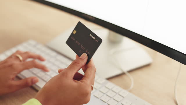 Woman hands, business credit card and computer for ecommerce, finance and accounting in office at night. Closeup worker, internet payment and online shopping of budget, fintech and investment banking