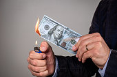Person burning a hundred dollar bill.