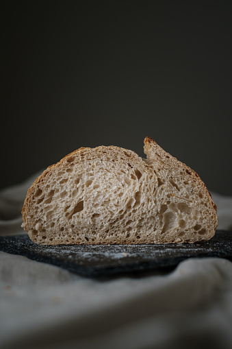 Artisan Batard Sourdough healthy Bread. Open crumb high hydration Sourdough french country bread set on dark background.