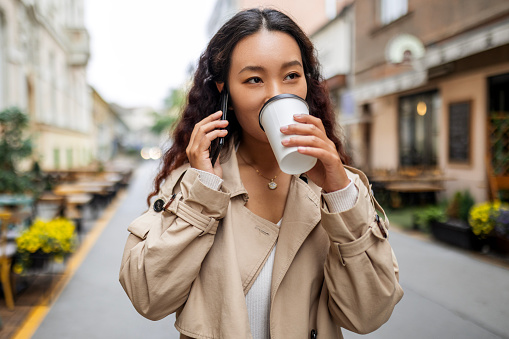 Businesswoman walking outdoors talking on smart phone
