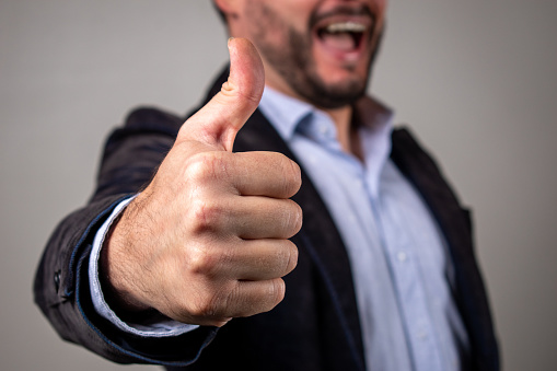 Man with thumb up. Elegant man putting his thumb up. Happy man making a thumbs up gesture. Very satisfied person