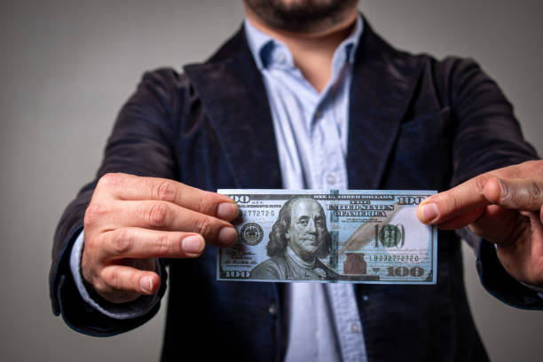 istock Person holding a hundred dollar bill. 1493172988