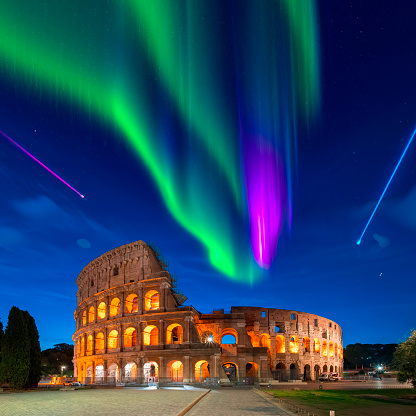 Beautiful bright green northern light over Colosseum in Rome (Roma) at night. Scenic of surreal cityscape with aurora borealis over skyline on twilight time. Coliseum landmark of Italy. Dreamscape.