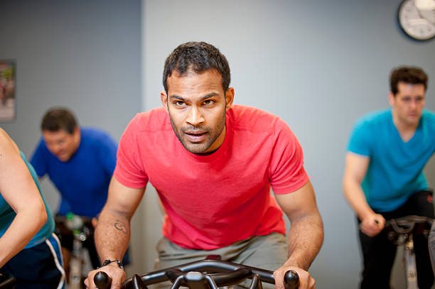 человек, используя вид машины в тренажерный зал - exercising sport gym spinning стоковые фото и изображения