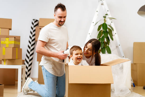 istock Parents and son packing boxes and moving into a new home 1493174023