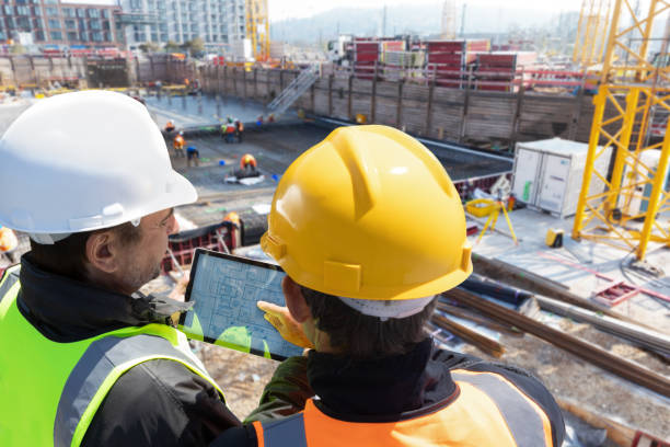 Two engineer architect construction worker on construction site with tablet computer working together in teamwork - fotografia de stock