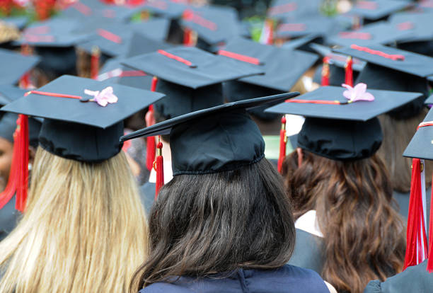 istock Female graduates with cap and gown at commencement. 1493177731
