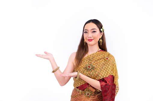 Thai woman in elegant wealthy  traditional dress doing hand presenting gesture for promoting culture in Thailand isolated on the white background