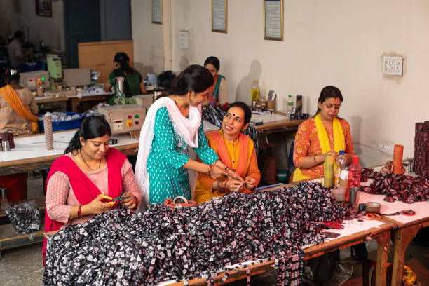 istock Manager inspecting workers cutting garments at textile factory 1493187825