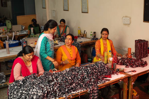 istock Manager inspecting workers cutting garments at textile factory 1493187883