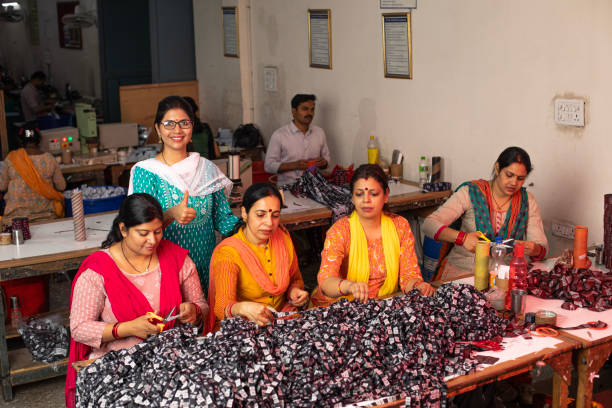 istock Manager inspecting workers cutting garments at textile factory 1493187995
