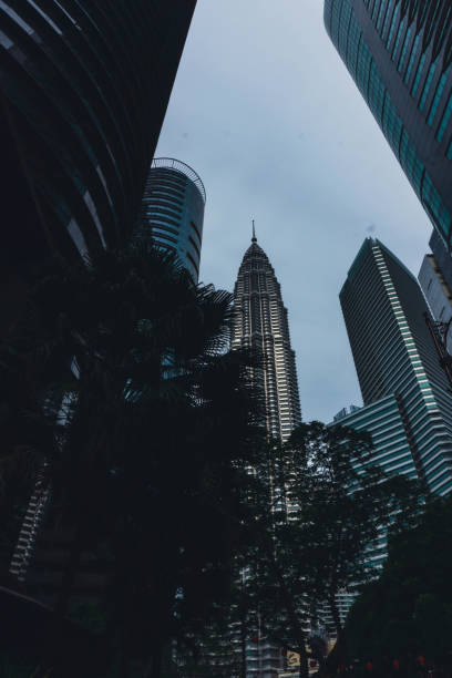 vue de la tour petronas depuis la rue - kuala lumpur skyline traffic sunset photos et images de collection