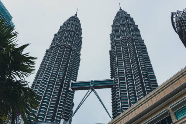 vue de la tour petronas depuis la rue - kuala lumpur skyline traffic sunset photos et images de collection