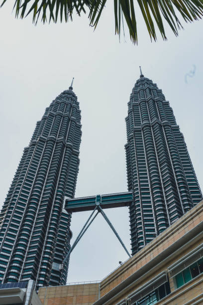 vue de la tour petronas depuis la rue - kuala lumpur skyline traffic sunset photos et images de collection