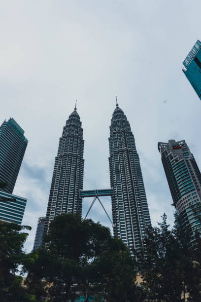 vue de la tour petronas depuis la rue - kuala lumpur skyline traffic sunset photos et images de collection