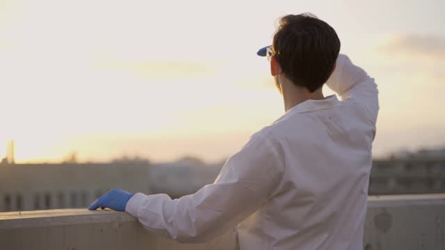 Doctor or scientist raising his hand and looking at the sun rising or setting