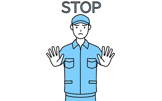 Man in hat and work clothes with his hands out in front of his body, signaling a stop.