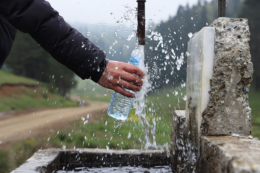 Man filling water in plastic bottle