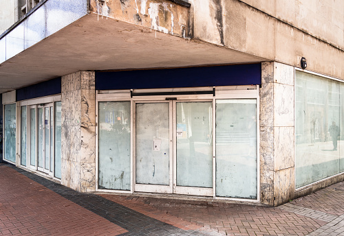 The exterior of a closed shop in a large, run down building in the city centre of Birmingham, England.