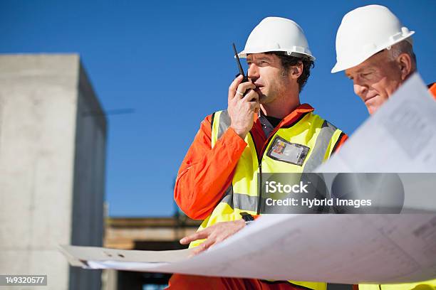 Lavoratori Lettura Cianografie Sul Sito - Fotografie stock e altre immagini di Walkie-talkie - Walkie-talkie, 35-39 anni, 50-54 anni