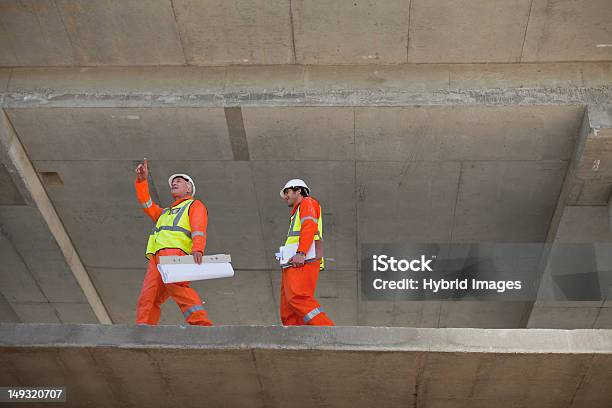 Workers Walking At Construction Site Stock Photo - Download Image Now - At The Edge Of, Concrete, Examining