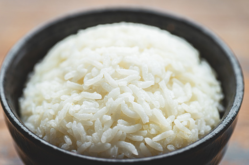 A bowl of rice on a wooden board macrophotography