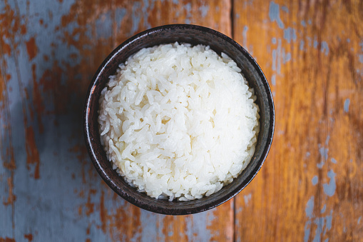 A bowl of rice on a wooden board macrophotography