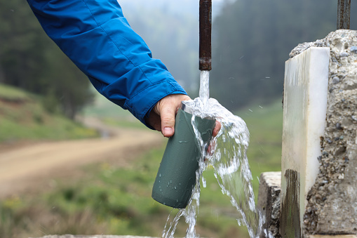 Man filling water in mug