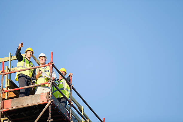 Workers standing on scaffolding on site  scaffolding stock pictures, royalty-free photos & images