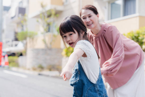 una ragazza che fa una passeggiata in città con sua nonna - toddler music asian ethnicity child foto e immagini stock