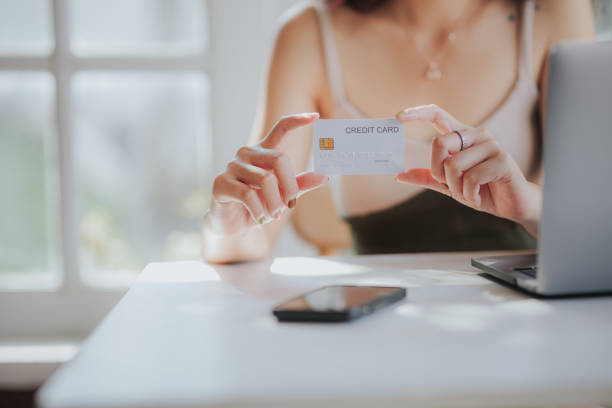 istock online payment Young woman's hand holding a credit card and using a smartphone for online shopping 1493212929
