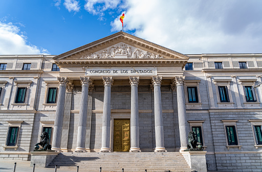Madrid, Spain. April 15, 2023. Horizontal image of the main facade of the congress of deputies of spain, in the city of madrid on a sunny day with clouds.