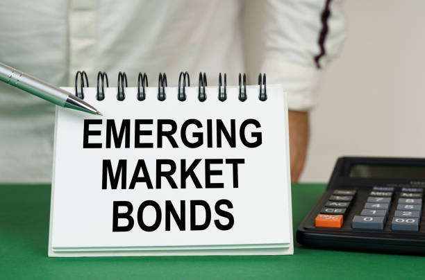 istock On a green surface, a calculator and a notepad with the inscription - emerging market bonds 1493215355