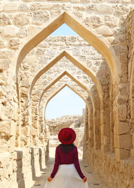 Female Visitor Walking Along the Iconic Archways of Qal'at al-Bahrain Or the Portuguese Fort in Manama, Bahrain, ( Self Portrait )