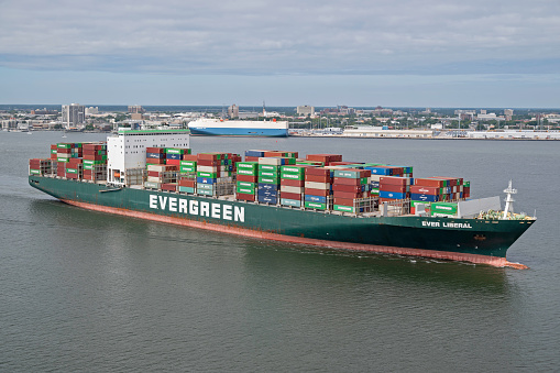 Charleston, SC, USA - May 25, 2023: Liberal, a 335-meter container vessel owned by Evergreen Marine Corporation and flagged to the United Kingdom, sails into Charleston Harbor.