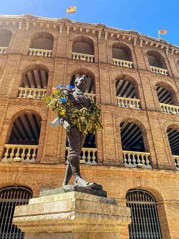 Valencia, Spain - May 17, 2023: Memorial monument with flowers garland in front of the bullring in the city downtown. It remembers Manolo Montoliu a Valencian bullfighter that died while performing in Sevilla