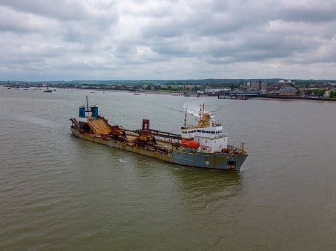 This aerial drone photo shows a large ship sailing on the river Thames in England.