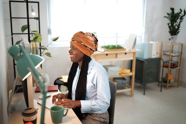 istock Smiling well dressed businesswoman with headscarf using desktop pc at home office 1493240635
