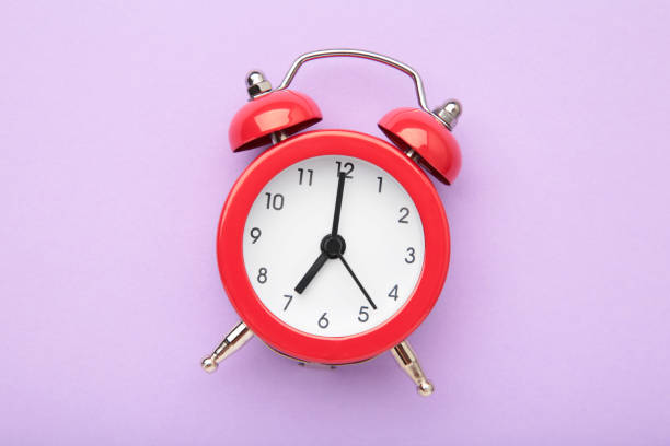 istock Red vintage alarm clock on purple background. Space for text 1493241969