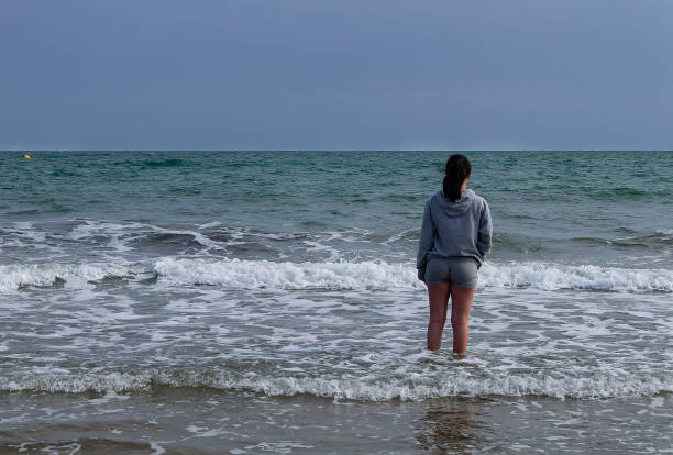 istock young woman looking at the sea inside the beach shore, copy space 1493245171