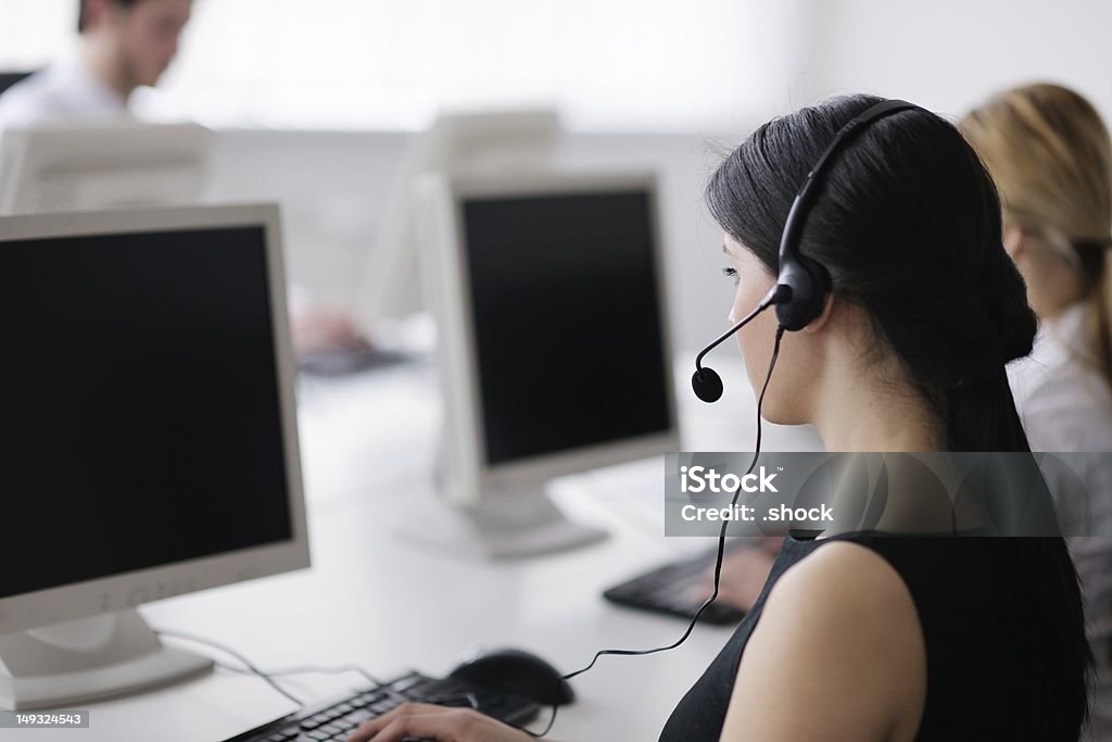 People wearing headsets working a customer service help desk business people group with  headphones giving support in  help desk office to customers, manager giving training and education instructions Adult Stock Photo
